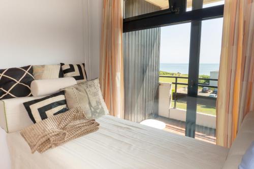 a bedroom with a bed with a view of the ocean at FEWO Ferienresidenz Staberdorf Haus 76 Wohnung Nr 26 in Staberdorf