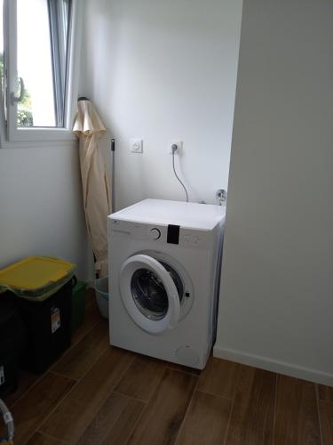 a washing machine in a laundry room with a window at Maison neuve à 2 pas des plus belles plages de Douarnenez - Classé Meublé de Tourisme 3 étoiles in Kerlaz