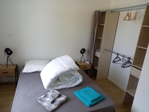a bed with white pillows and towels on it at Maison neuve à 2 pas des plus belles plages de Douarnenez - Classé Meublé de Tourisme 3 étoiles in Kerlaz