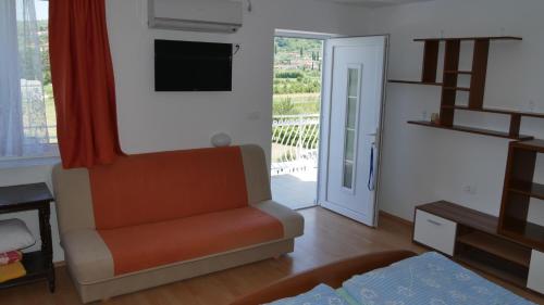 a living room with a couch and a sliding glass door at Penzion Palma in Sečovlje