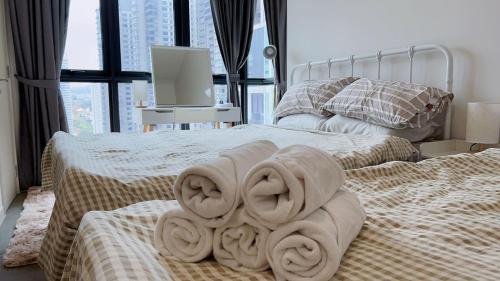 two beds with towels on them in a bedroom at TheOoak suite 4pax cozy home stay @mont kiara in Kuala Lumpur