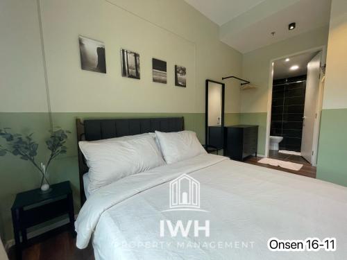 a bedroom with a bed with a white comforter at Ipoh Sunway Onsen Suites and Tambun Guesthouse , 3-14pax 2parking by IWH in Ipoh