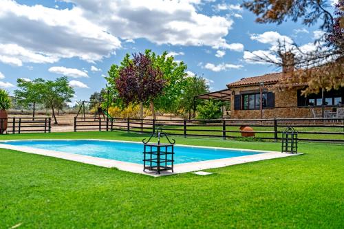 a swimming pool in the grass next to a house at CR El Portezuelo Boutique Experience in Fuentelabrada de los Montes