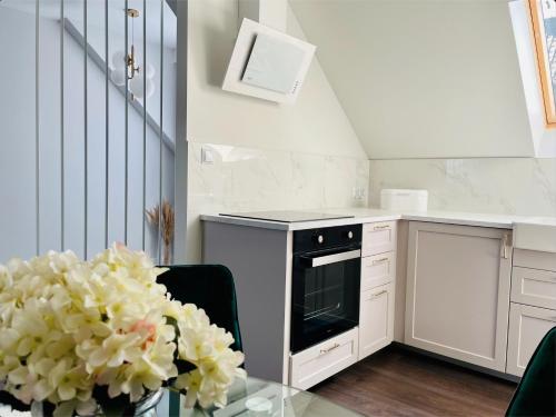 a kitchen with a glass table with a vase of flowers at DeerHome Apartment in Czarny Dunajec