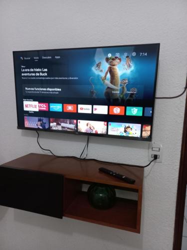 a flat screen tv on a stand with a remote control at Cómodo & confortable apartamento. 5 minutos del aeropuerto in Mexico City