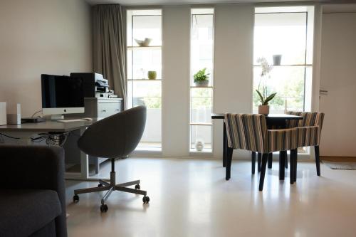 Habitación con escritorio, ordenador y sillas. en NYON - Appartement meublé tout confort, en Nyon