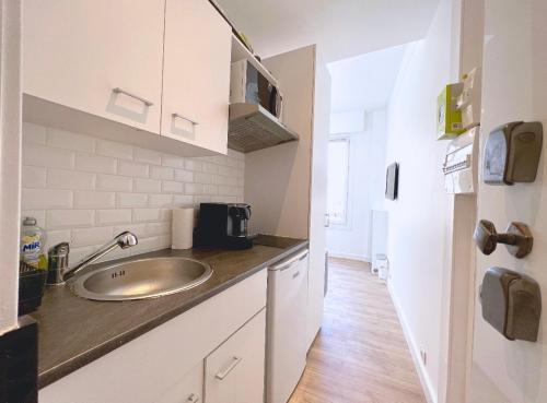 a kitchen with a sink and a counter top at Cosy studio ensoleillé - centre-ville – TRAM/AC in Nice