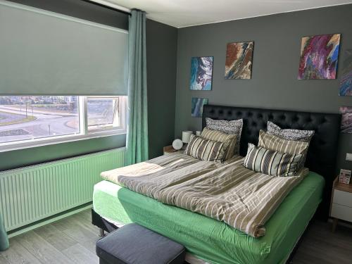 um quarto com uma cama verde e uma janela em Eskivellir 11 em Hafnarfjördur