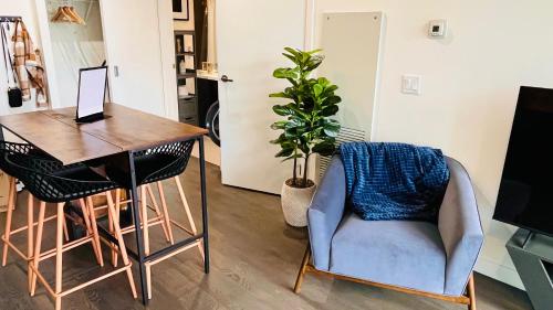 Habitación con mesa, silla y escritorio. en LUXURY Downtown Sunset Getaway - Your Home Away From Home - Fully Stocked Kitchen, Gym, Balcony, FREE PARKING en Calgary