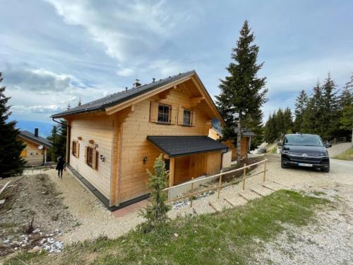 a house with a car parked in front of it at Chalet Montana Royal XL Koralpe in Hartelsberg