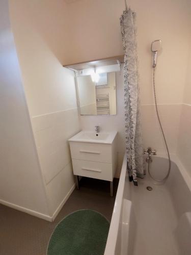une petite salle de bain avec un lavabo et un miroir dans l'établissement La Maison de la Plage, à Arromanches-les-Bains