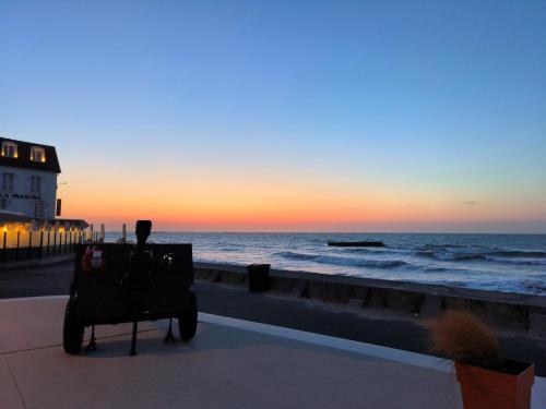 a view of the ocean from the beach at sunset at La Maison de la Plage in Arromanches-les-Bains