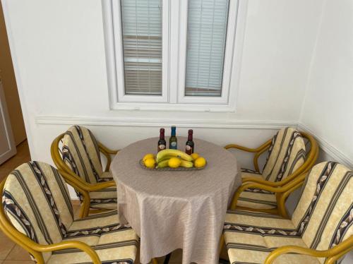 a table with chairs and a bowl of fruit on it at Jelić apartmani in Sutomore