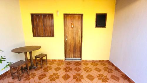 um quarto com uma mesa, um banco e uma porta em Chalé da Vó em Vargem Bonita