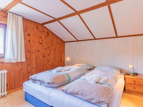 2 Betten in einem Zimmer mit Holzwänden in der Unterkunft Gaisbergblick in Kirchberg in Tirol