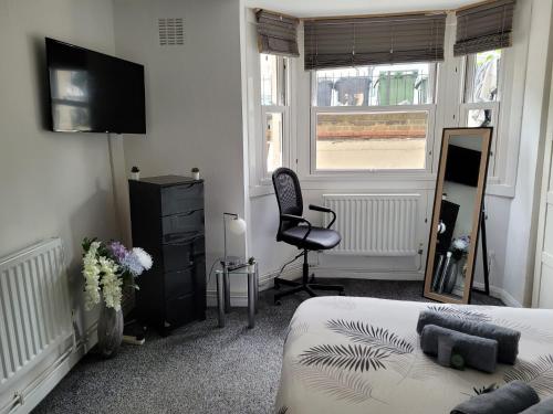a bedroom with a bed and a chair and a television at 2 bed luxury flat in Lambeth in London