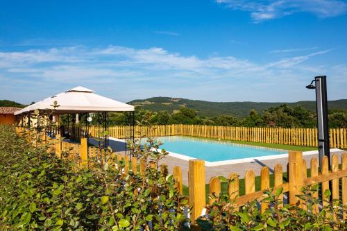 uma piscina com um guarda-sol e uma cerca em La Poggiata em Monterotondo