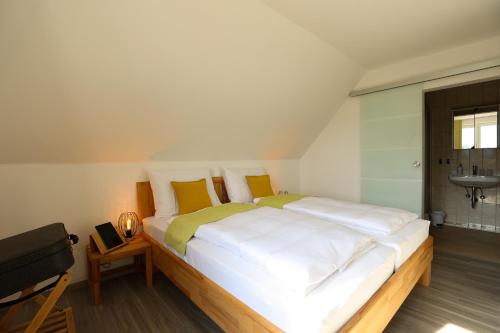 a bedroom with a large bed with white sheets and yellow pillows at Panoramablick Scheifling in Lind bei Scheifling