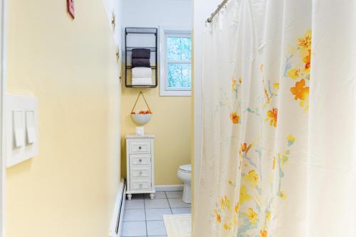 a bathroom with a shower curtain with flowers on it at Royal Glam-Marilyn inspired 1BD - 30 Min to NYC in Edgewater
