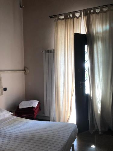 a bedroom with a bed and a window with curtains at Il Capisterium in Norcia