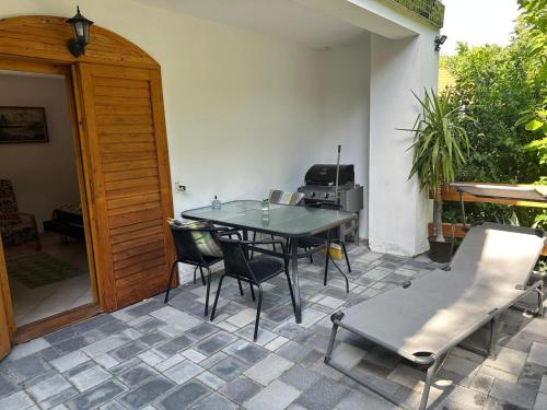 eine Terrasse mit einem Tisch und Stühlen auf einer Terrasse in der Unterkunft Parraghegy Apartman in Zalaszántó