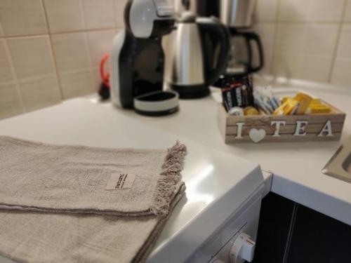 a kitchen counter with a towel and a coffee maker at Greg's Home Volos in Volos