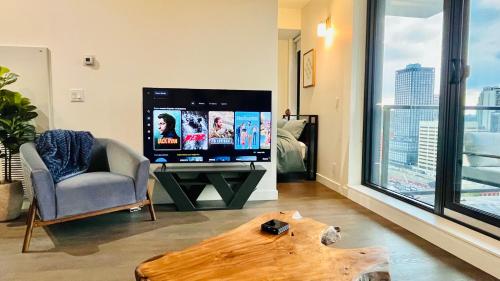 A television and/or entertainment centre at LUXURY Downtown Sunset Getaway - Your Home Away From Home - Fully Stocked Kitchen, Gym, Balcony, FREE PARKING