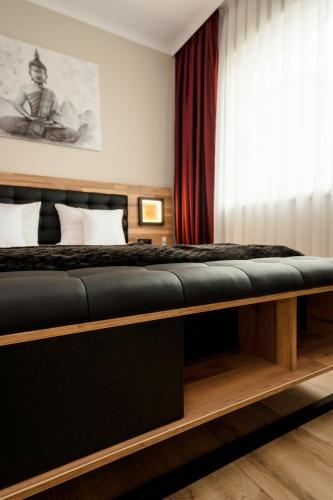 a bedroom with a bed with a black bench at Backyard Jacuzzi House in Oradea