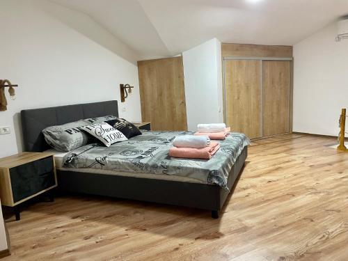 a bedroom with a bed and a wooden floor at Gallery City Center Apartment in Skopje