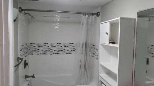 a white bathroom with a shower with a shower curtain at The Mall of America(MOA) House in Bloomington
