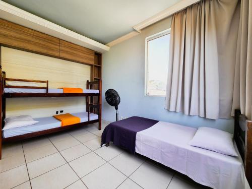 a bedroom with two bunk beds and a window at Trem bão de dormir hostel in Belo Horizonte