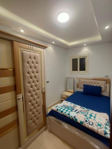 - une petite chambre avec un lit et une porte dans l'établissement African Shield Company, au Caire