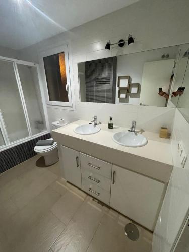 a bathroom with two sinks and a toilet at Casa Kizkur in Tarifa