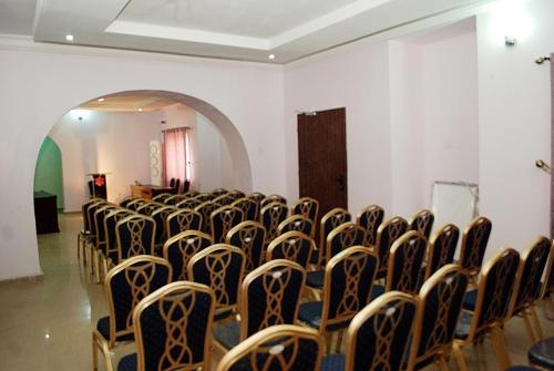 een kamer met rijen stoelen in een kamer met een boog bij HP Pavilion in Abuja