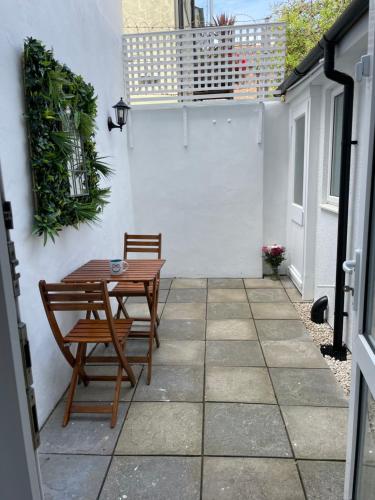 patio con tavolo in legno e panca di Kemptown Courtyard Apartment a Brighton & Hove