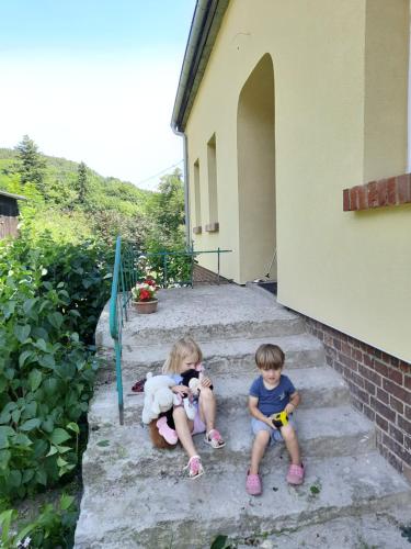 Perełka في Pieszyce: طفلين جالسين على درج منزل
