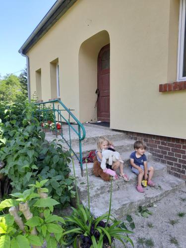 Perełka في Pieszyce: طفلين جالسين على درج منزل