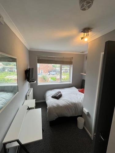a small bedroom with a bed and a window at 6 Bed 6 Bath House Fantastic for contractors & Groups in Luton