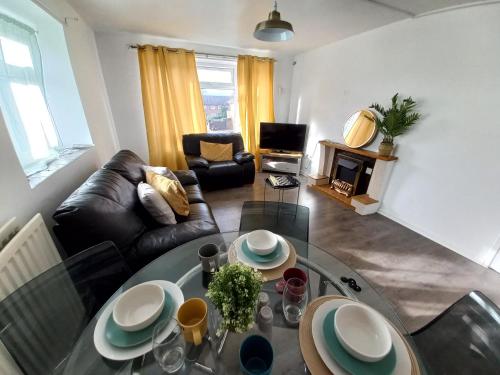 a living room with a glass table and a couch at Toni's Hub - 2 bed City Centre Apartment in Derby