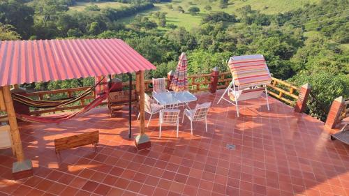 un patio con sillas y sombrillas en la azotea en Finca Ecoturistica La lomita, en Agua de Dios
