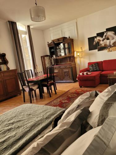 Una sala de estar con un sofá rojo y una mesa. en Studio Séquoia au pied du Château, en Saumur