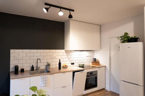 a kitchen with white cabinets and a white refrigerator at Central Park Apartments - Terrace in Brno