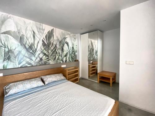 a bedroom with a bed and a painting on the wall at La Paratá Suites Mojácar in Mojácar