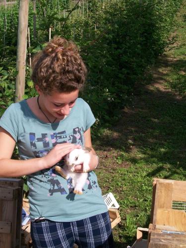 a young woman holding a baby lamb in her arms at Agritur Scoiattolo in Coredo