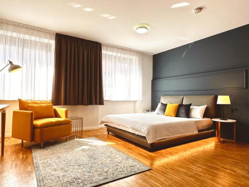 1 dormitorio con 1 cama y 1 silla en Stadthaus Neckarsulm serviced apartments - Stadthaus Schrade, en Neckarsulm