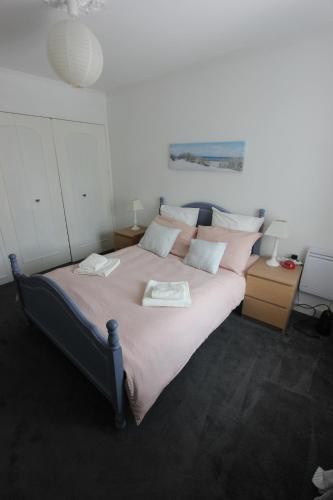 a bedroom with a large bed with pink pillows at La Charentaise des Lilas in Saint-Léger