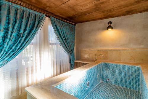 a bathroom with a tub with blue tiles on it at Atilla's Cave Hotel in Nevsehir