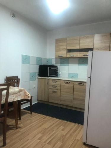 マヴロヴォにあるPetar Apartmentのキッチン(白い冷蔵庫、テーブル、テーブル、テーブル付)