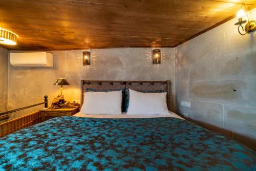 a bedroom with a large bed and a wooden ceiling at Atilla's Cave Hotel in Nevsehir