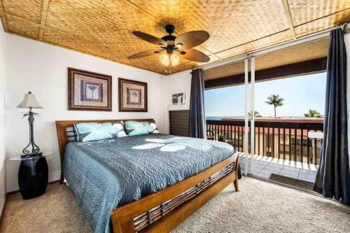 1 dormitorio con cama y ventana grande en Reduced Price! Top Floor Kailua Bay View Walk to Kona Village AC King Bed, en Kailua-Kona